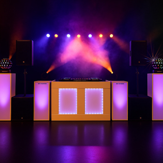 Verlichte DJ-opstelling met zuilen, speakers en kleurrijke podiumverlichting tegen zwarte achtergrond. Verlichte DJ-opstelling met zuilen, speakers en kleurrijke podiumverlichting tegen zwarte achtergrond.