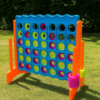 Groot Connect Four spel van kunststof met gekleurde schijven, opgesteld op een grasveld in een tuinomgeving Groot Connect Four spel van kunststof met gekleurde schijven, opgesteld op een grasveld in een tuinomgeving