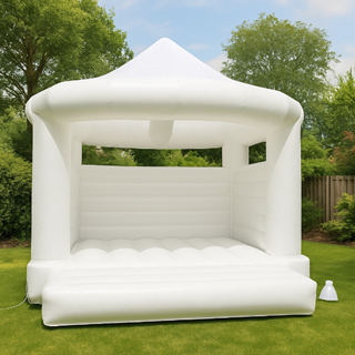 Wit springkussen in een groene tuin, perfect voor bruiloften of tuinfeesten Wit springkussen in een groene tuin, perfect voor bruiloften of tuinfeesten